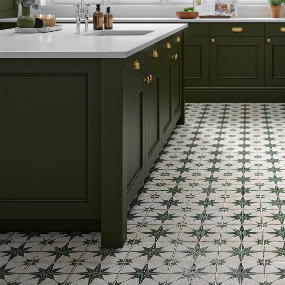 Celestial sage patterned floor tiles in a dark green kitchen